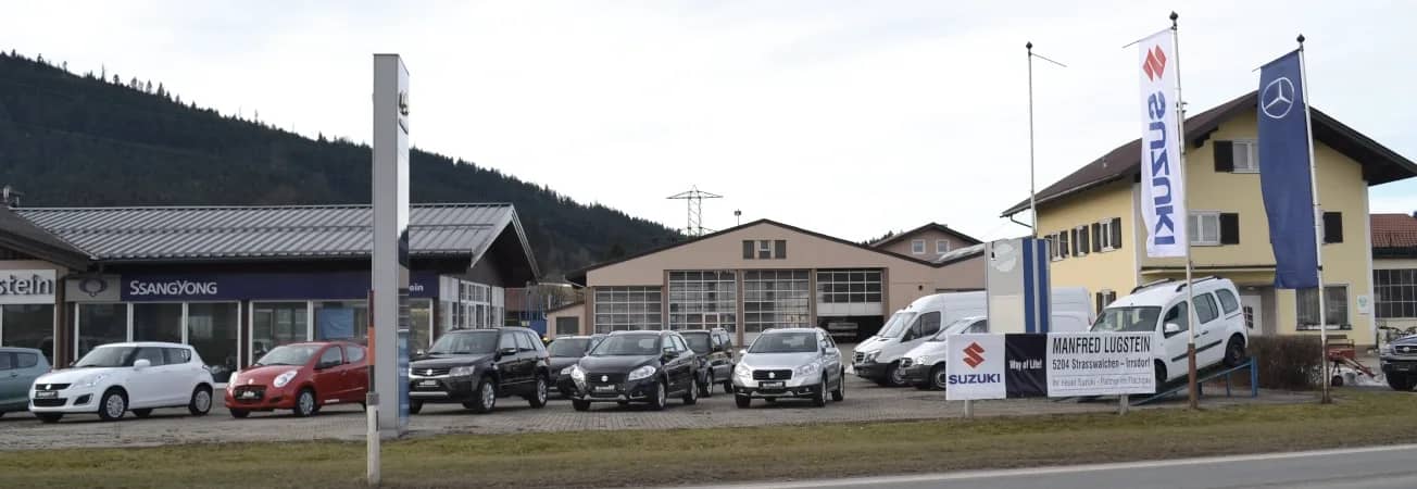 Autohaus Lugstein in Straßwalchen mit Mercedes-Benz- und Suzuki-Fahnen